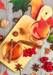 Autumn hot beverage in a glass with fruits and spices