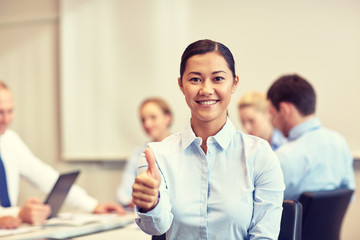 group of smiling businesspeople meeting in office