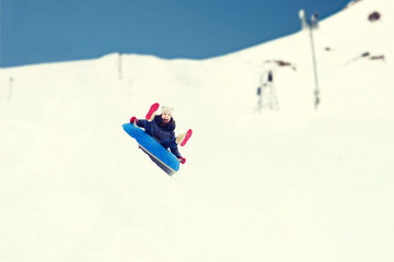 happy teenage girl sliding down on snow tube