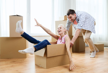 couple with cardboard boxes having fun at new home
