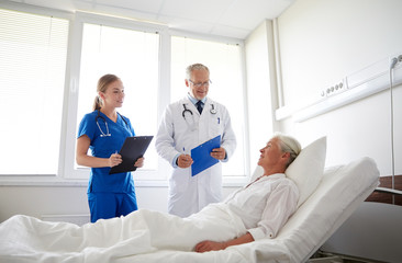 doctor and nurse visiting senior woman at hospital