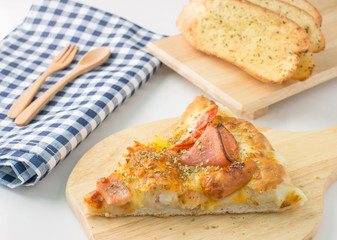 hawaiian pizza with garlic bread on wood table