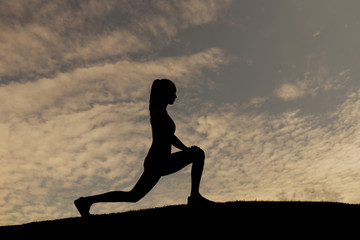 Silhouette of the the sportswoman on the background of sunset.