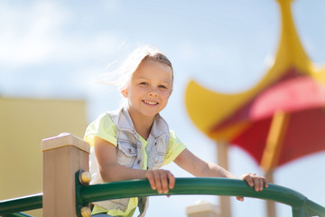 happy little girl climbing on children playground