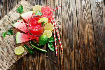 Watermelon smoothie with mint and slices of lime on the wooden background