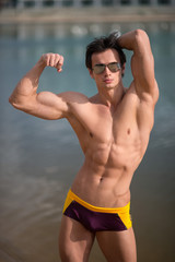 Obraz premium Portrait of a sporty, athletic, muscular sexy man in swimtrunks