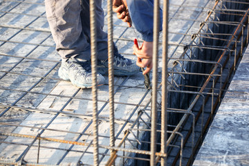 workers make reinforcement for concrete foundation
