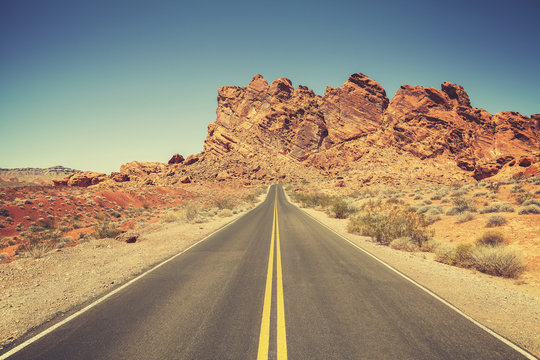 Retro stylized road through rocky desert, Nevada.