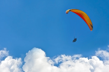A paraglider gliding over the clouds