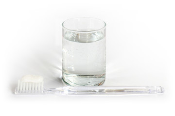 Toothbrush, toothpaste and a glass of water.
