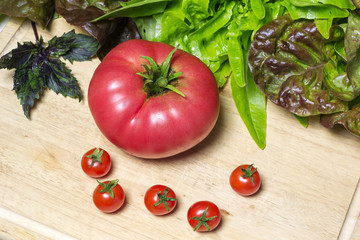 Fresh vine tomatoes and a large tomato with basil and lettuce 