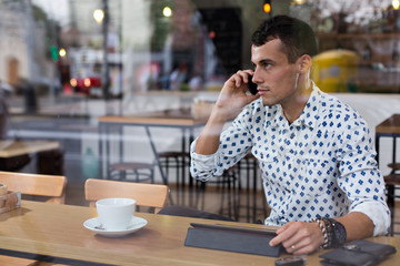 Businessman in a cafe talking on the phone