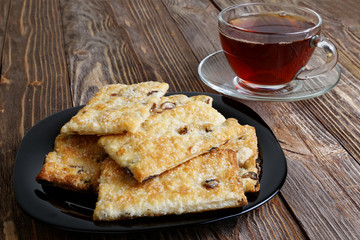Cookies and cup of tea on the dark brown wooden table