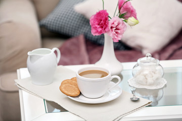 Cup of coffee on table in living room