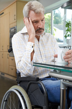 Depressed Woman Sitting In Wheelchair At Home