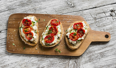 sandwich with goat cheese, sun-dried tomatoes and thyme, served on the Board at a bright wooden surface