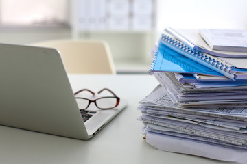 Stack of papers and glasses lying on table desaturated