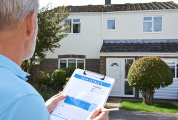 Builder Preparing Estimate For Exterior Home Improvement