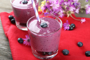 Glasses of blueberry smoothie on red napkin, closeup