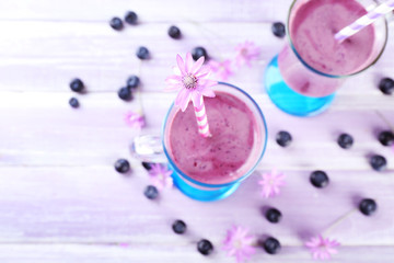 Glasses of blueberry smoothie on wooden table, closeup