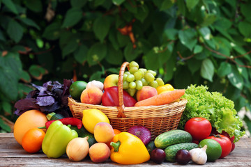 Heap of fresh fruits and vegetables in basket on table outdoors