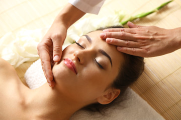 Fototapeta premium Young woman in beauty spa salon enjoying head massage