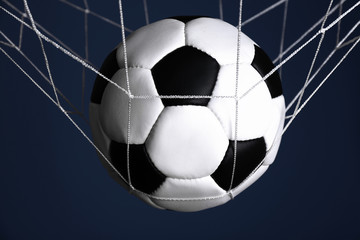Naklejka premium Soccer ball in the net on blue background