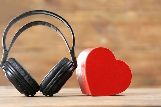 black headphones with heart on unfocused brown background