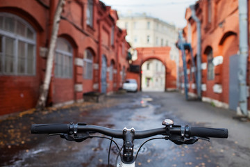 bicycle wheel and the street with brick houses
