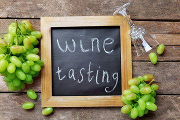 composition of grape, frame and empty glass on wooden background