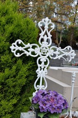 Croix blanche en ferraille dans un cimetière