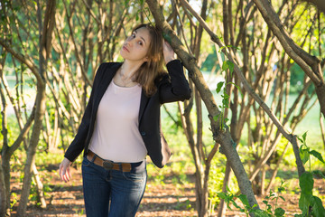 Pretty young woman under tree on sunny bright day