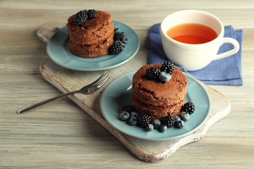 Cakes with berries and tea on the table