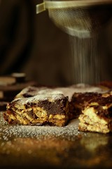 Pours powdered sugar on homemade bread or chocolate cake