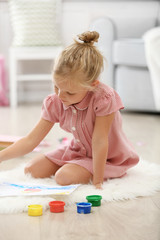 Fototapeta premium Little girl drawing in the room