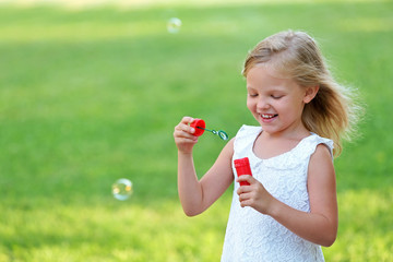 Cute girl blowing soap bubbles