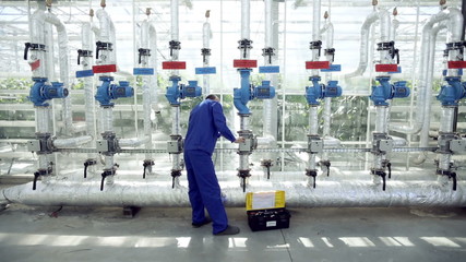 Technician repairing the heating system in the greenhouse.