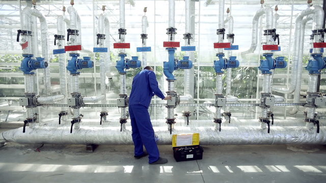 Technician repairing the heating system in the greenhouse.