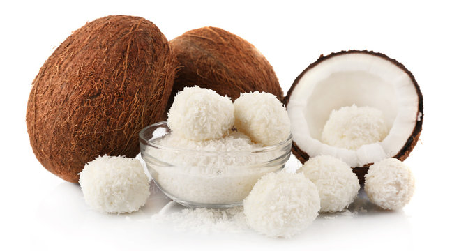 Candies in coconut flakes and fresh coconut isolated on white