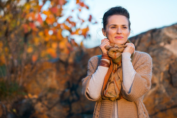 Smiling brown-haired woman relaxing in autumn park