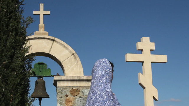 Religious female praying with clasped hands in solitude, symbol of Christianity