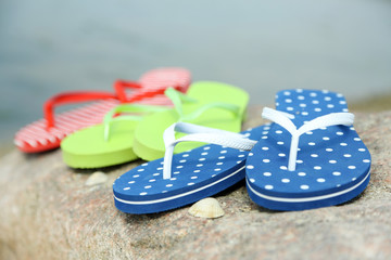 Bright flip-flops on stone, nature background