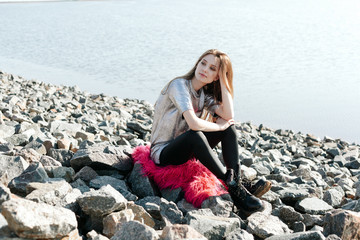 young woman enjoy in sun on stone beach by sea