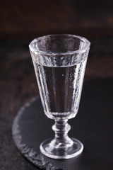 Shot of vodka with chili peppers on a black background.selective focus