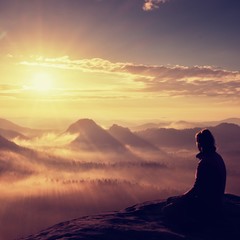 Beautiful  young long hair girl tourist enjoy daybreak on the sharp corner of sandstone rock and...