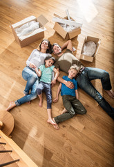 Fototapeta na wymiar a family laying in their new flat with cardboard boxes
