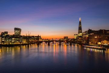 London cityscape during sunrise - river Thames with silhouettes of modern skyscrapers