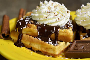 Homemade waffles with chocolate and whipped cream.