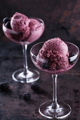 BlackBerry ice cream with fresh blackberries in a glass sundae dish. selective focus