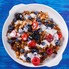Homemade granola with fresh berries and honey.